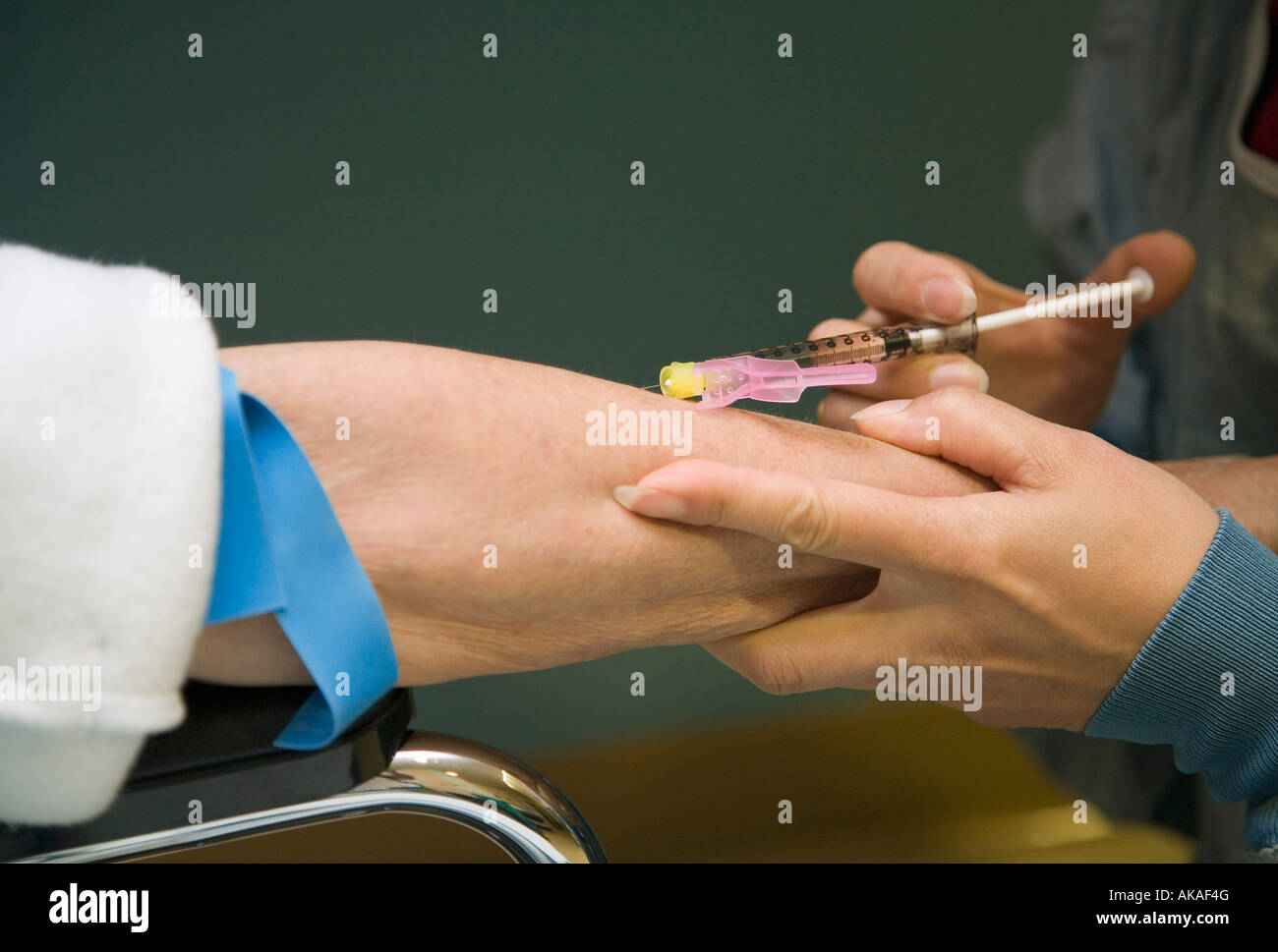 Medico paziente dando un ago Foto Stock
