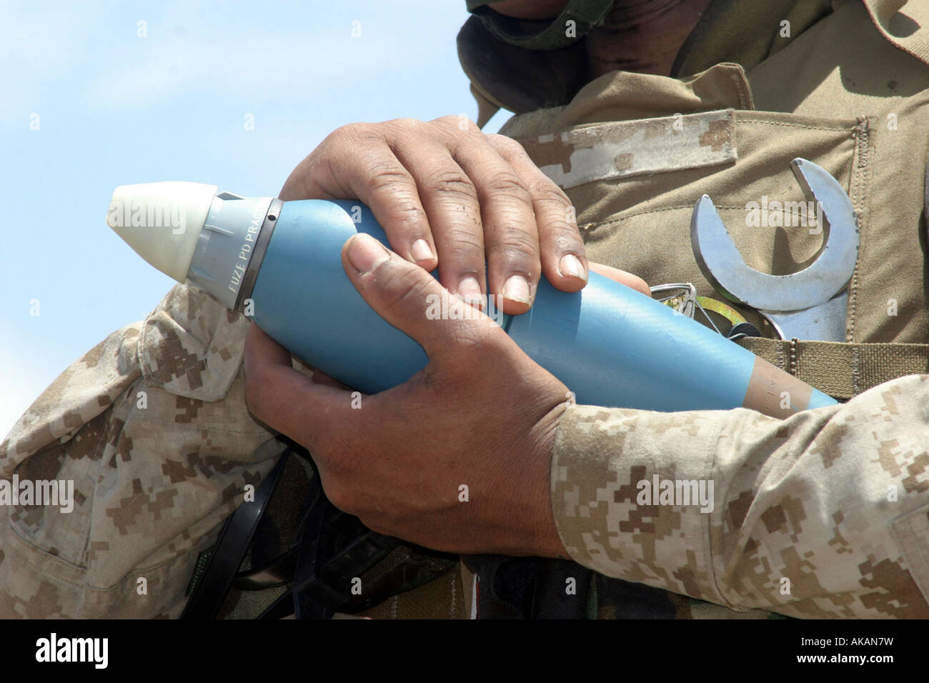 Un soldato tiene un pezzo di munizioni. Foto Stock
