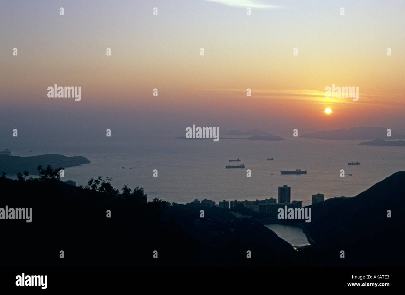 Porto di Hong Kong al tramonto con le navi al di ancoraggio Foto Stock