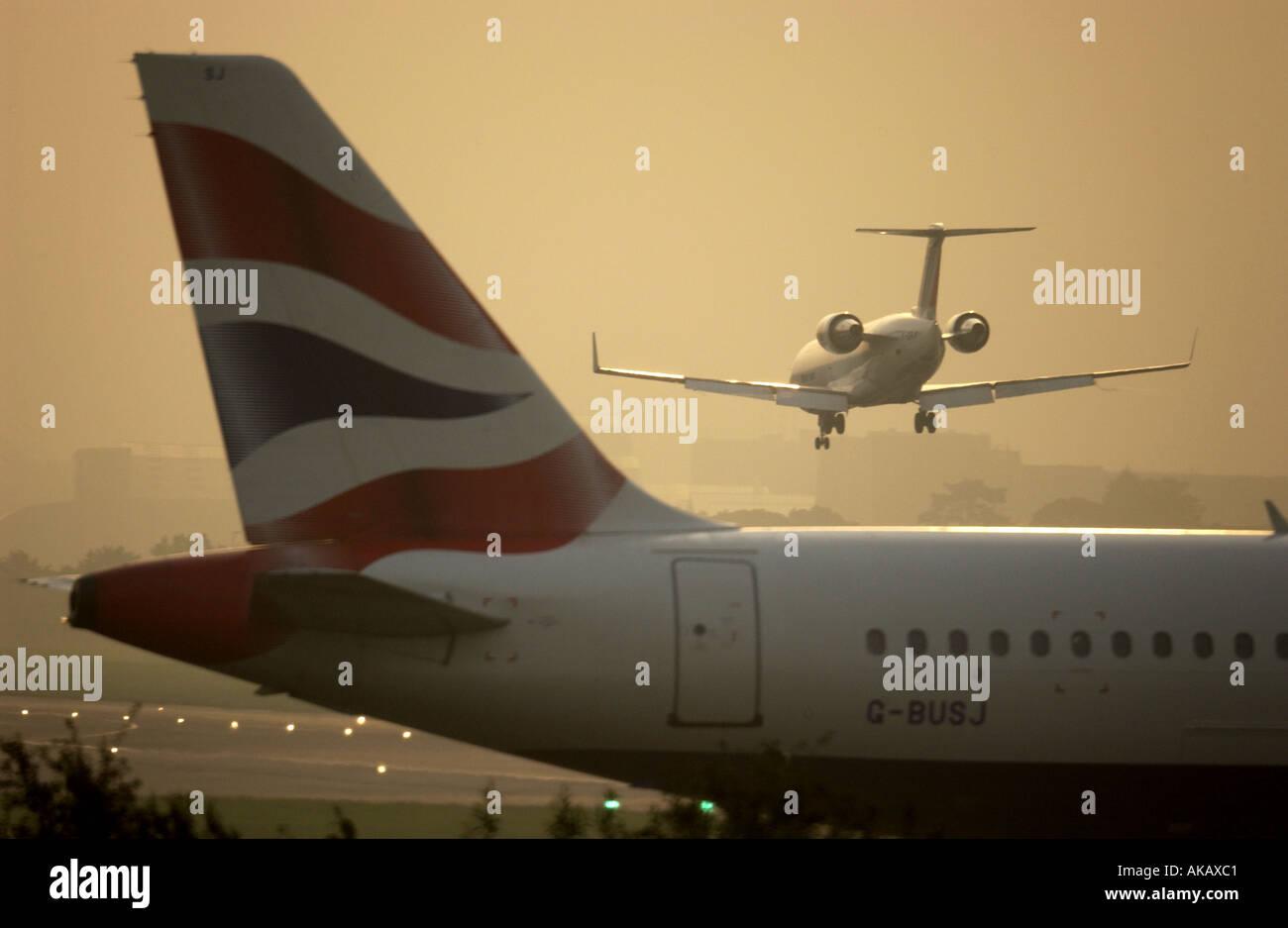 Un Air France BritAir Jet entra in terra all'alba sopra la coda di un British Airways Jet in attesa di prendere il via a Londra Gatwick Foto Stock
