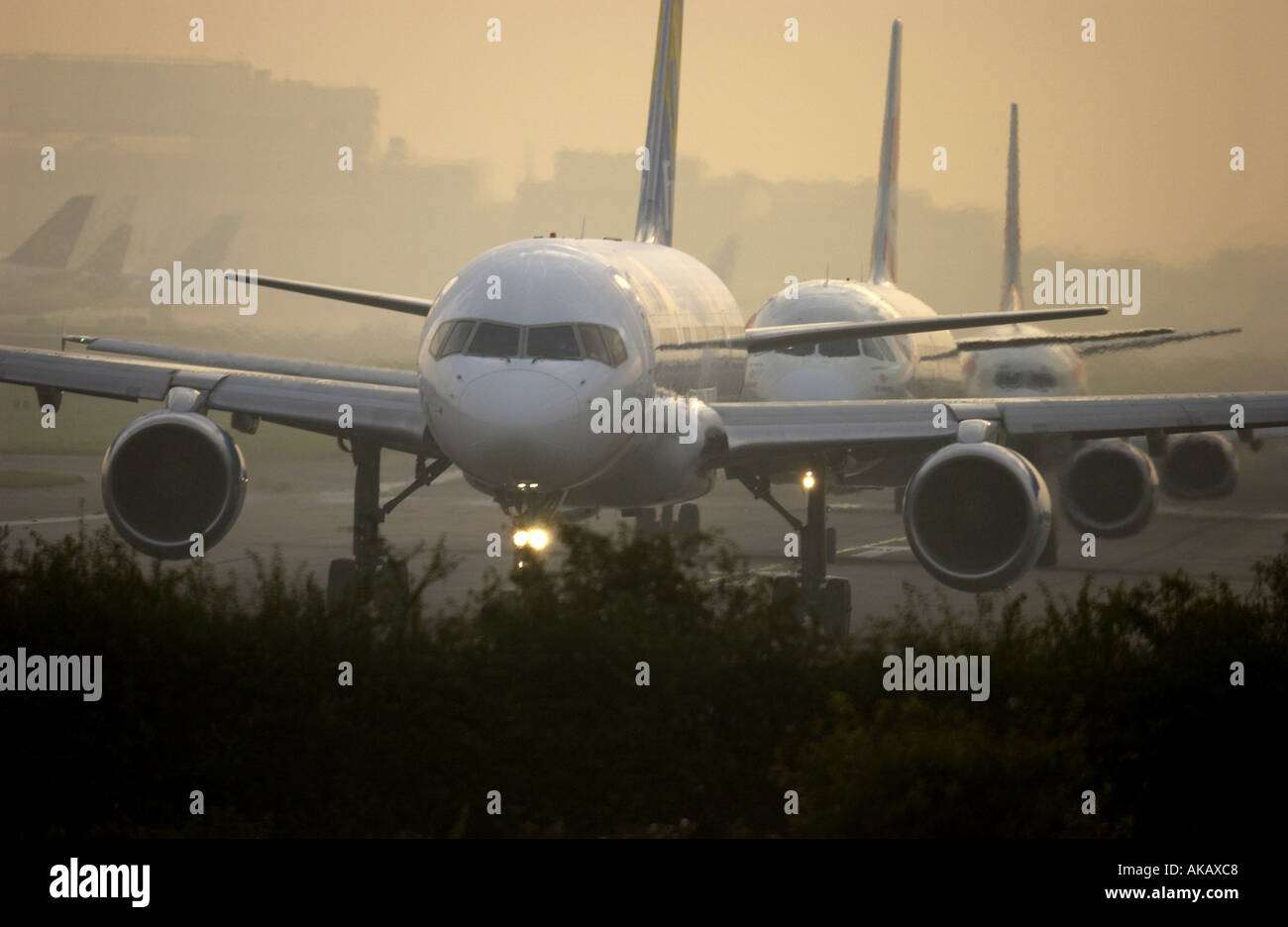 Una linea di aeroplani di linea a getto hanno per la coda ed attendere il loro turno per il decollo dall'aeroporto Gatwick di Londra all'alba Foto Stock