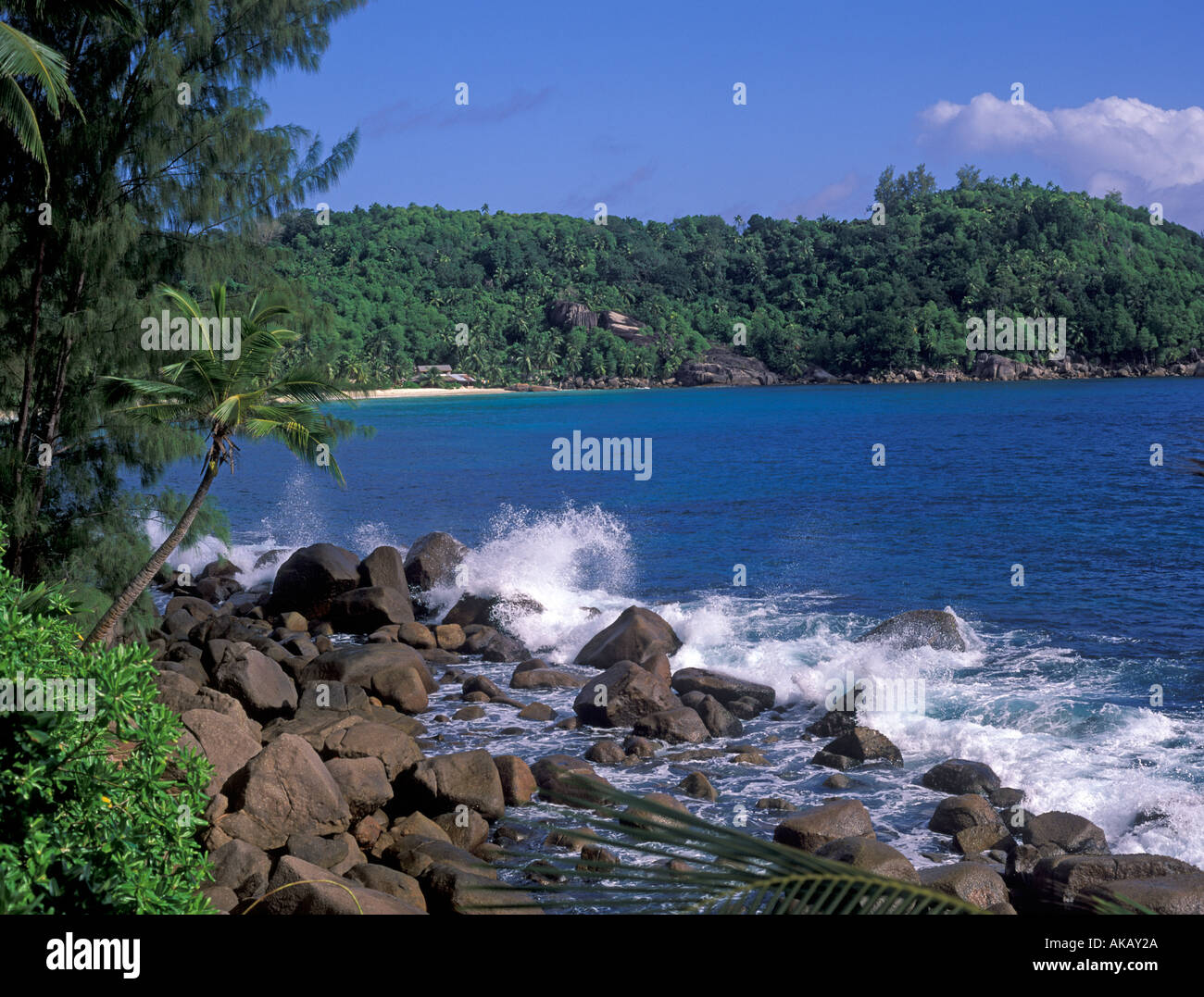 Onde che si infrangono sulla spiaggia di una baia delle Seychelles Foto Stock