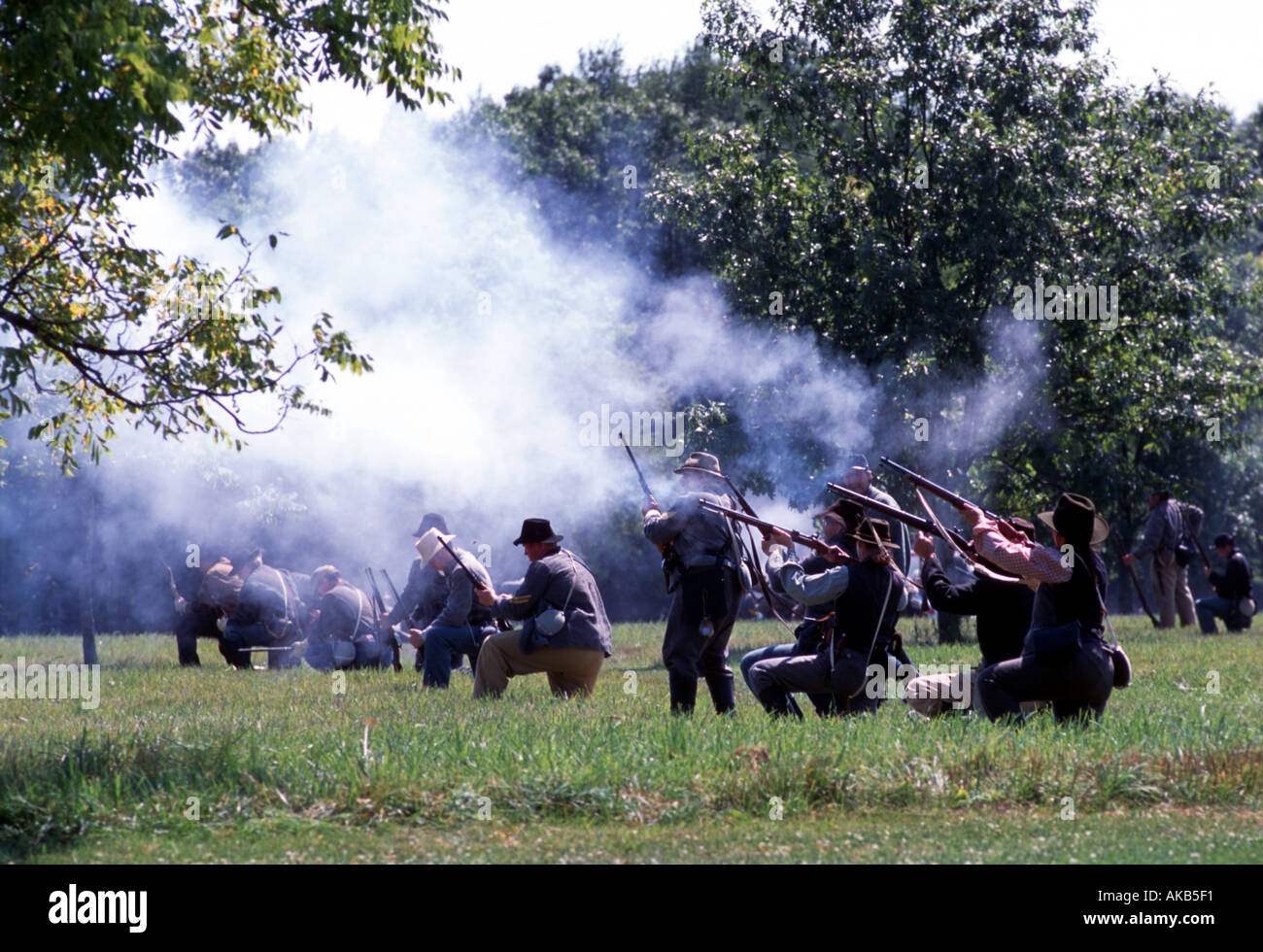 Soldati a piedi la linea fino al loro carico di ginocchia e puntamento moschetti della guerra civile rievocazione storica Foto Stock