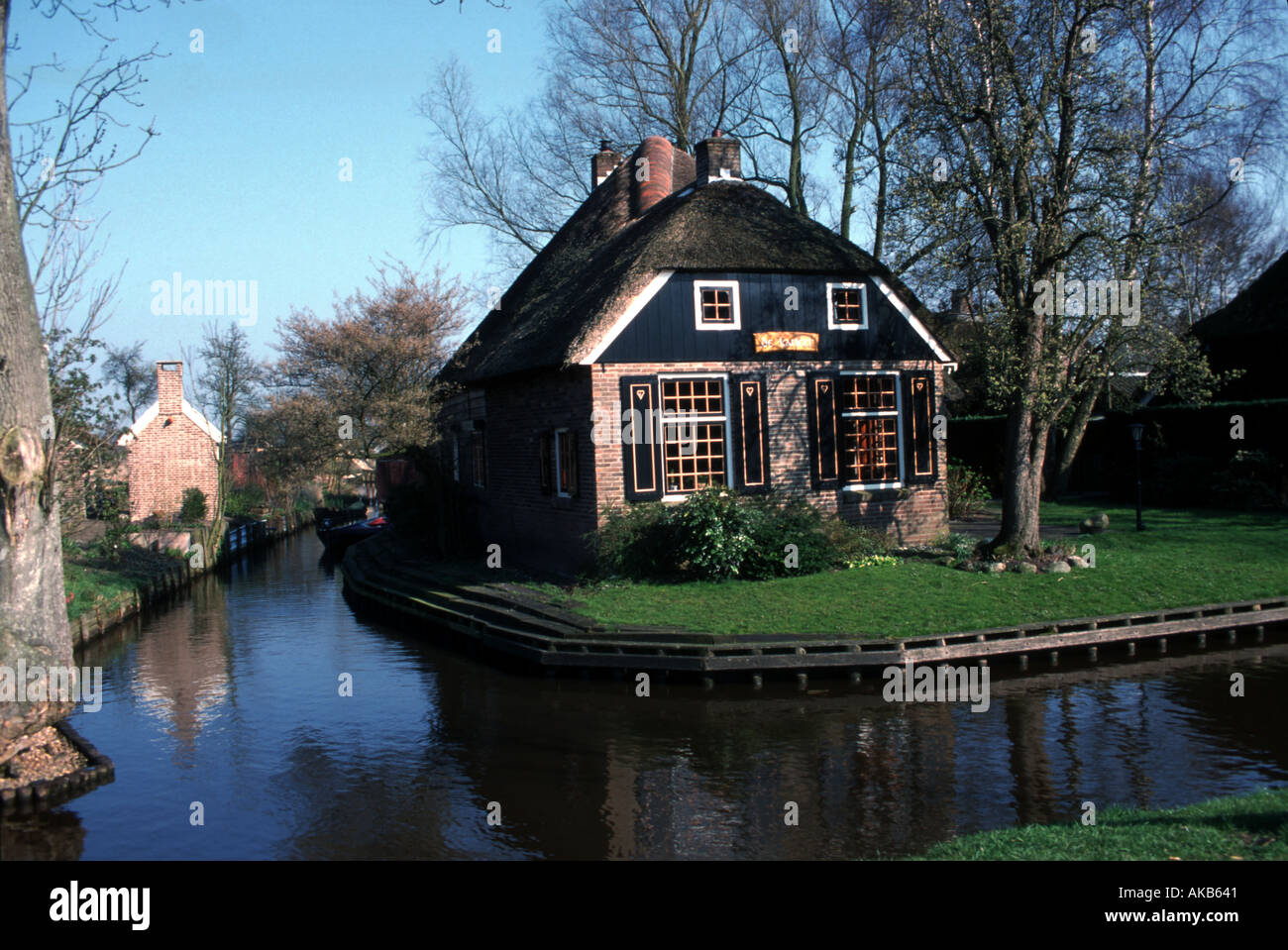 Un caratteristico cottage struttura con molte finestre è posizionato su un villaggio arrotondati angolo circondata su due lati da una tranquilla Foto Stock