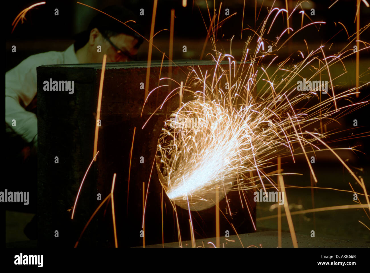 Chicago Impianto macinazione lavoratore utilizza la taglierina per levigare e terminare il foro nel blocco di acciaio doccia produzione di scintille Foto Stock