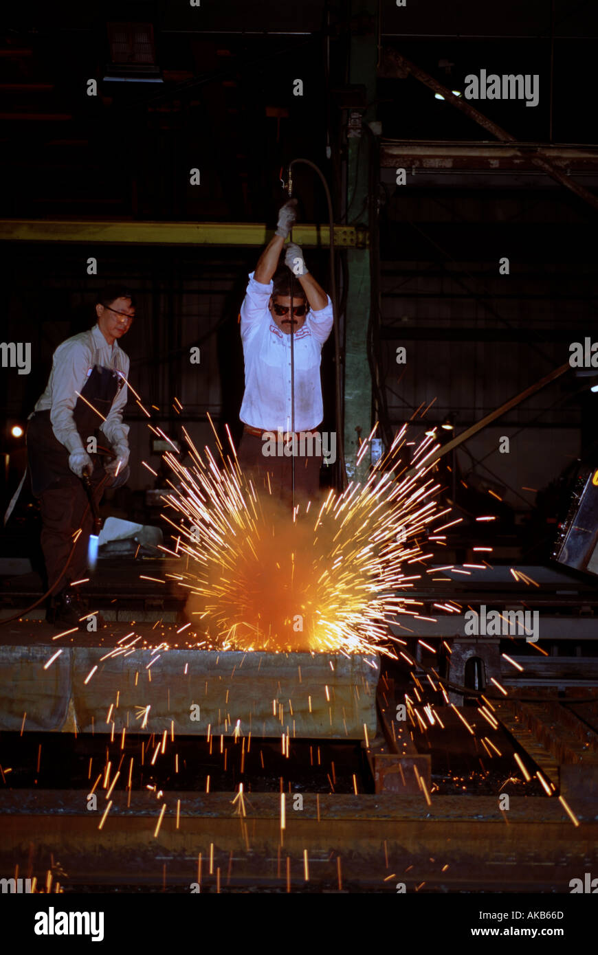 Chicago Impianto macinazione lavoratore spinge l'asta in acciaio attraverso la torcia producendo una doccia di scintille Foto Stock