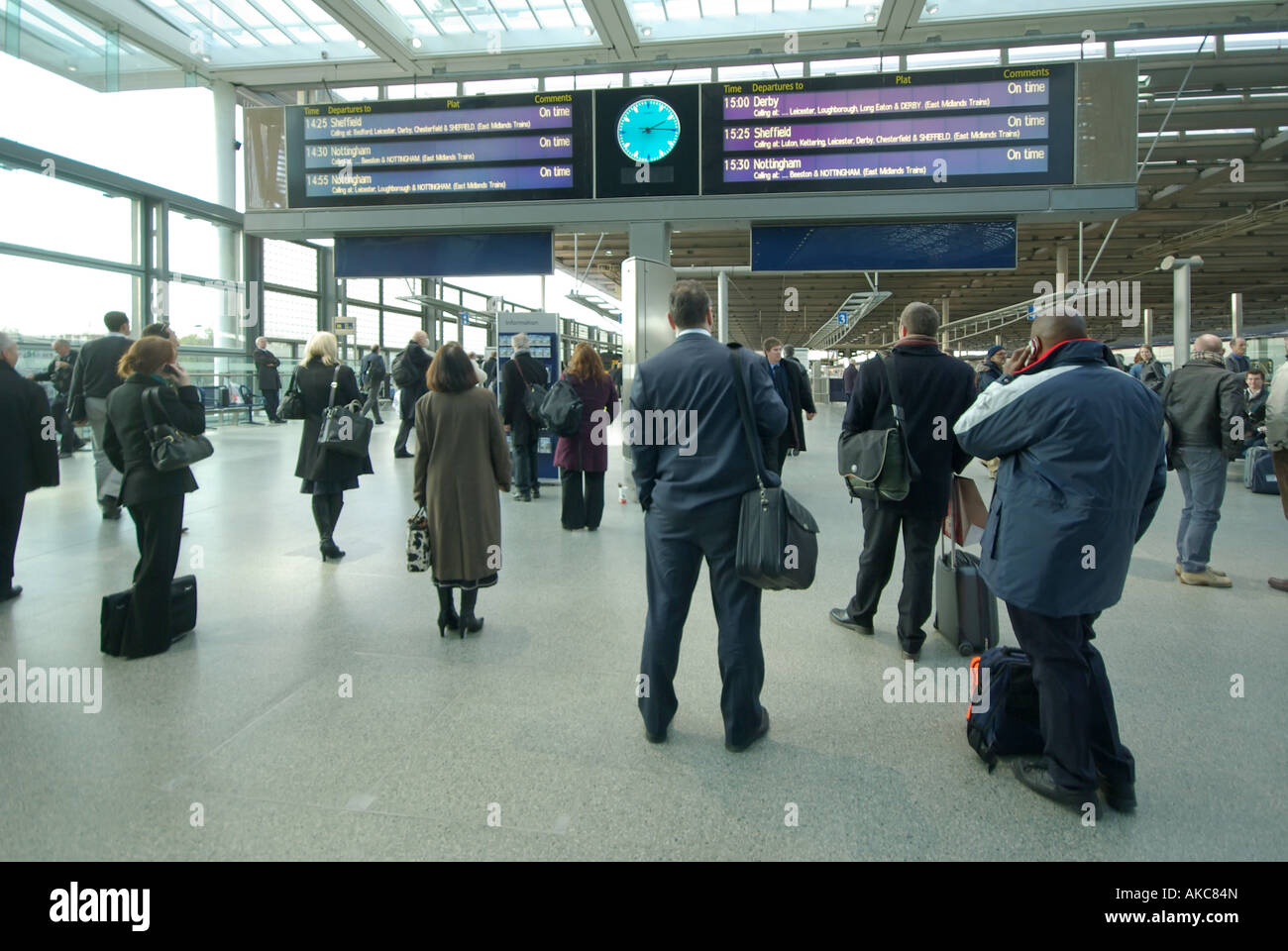 Passeggeri controllare gli orari dei treni a dalla stazione ferroviaria internazionale di St Pancras per i servizi domestici a nord e a sud-est dell' Inghilterra Londra Inghilterra REGNO UNITO Foto Stock