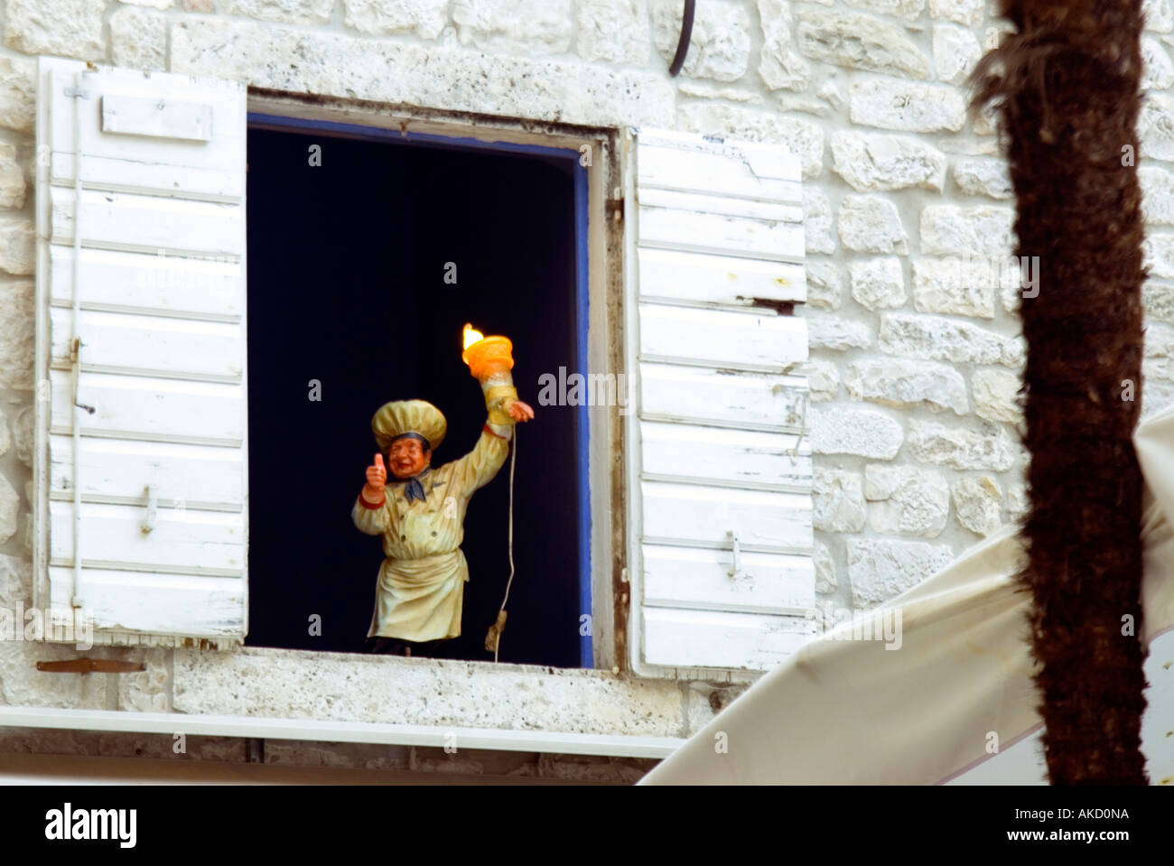 L' Europa sudorientale, Croazia, Dalmazia, Trogir, chef statuetta in finestra aperta con persiane di legno Foto Stock