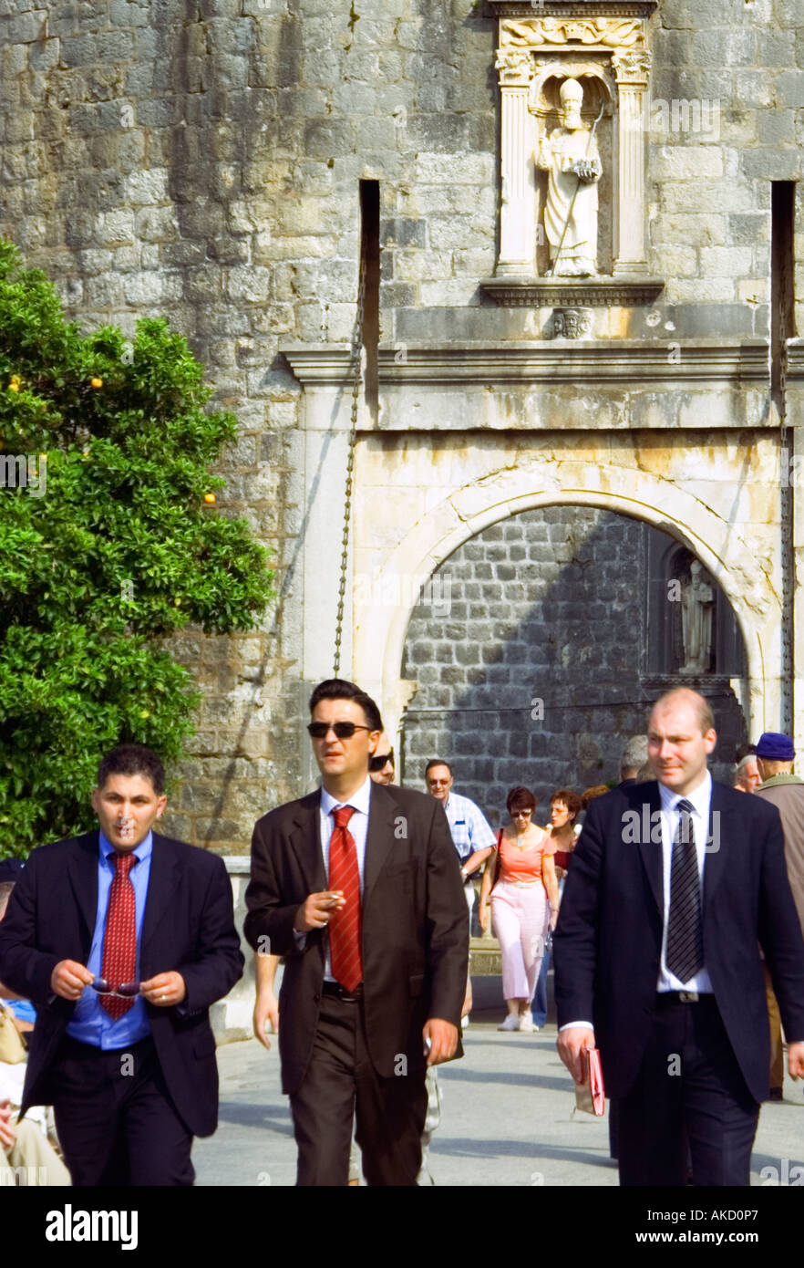 L' Europa sudorientale, Croazia, Dubrovnik, tre uomini a piedi attraverso il ponte levatoio Foto Stock
