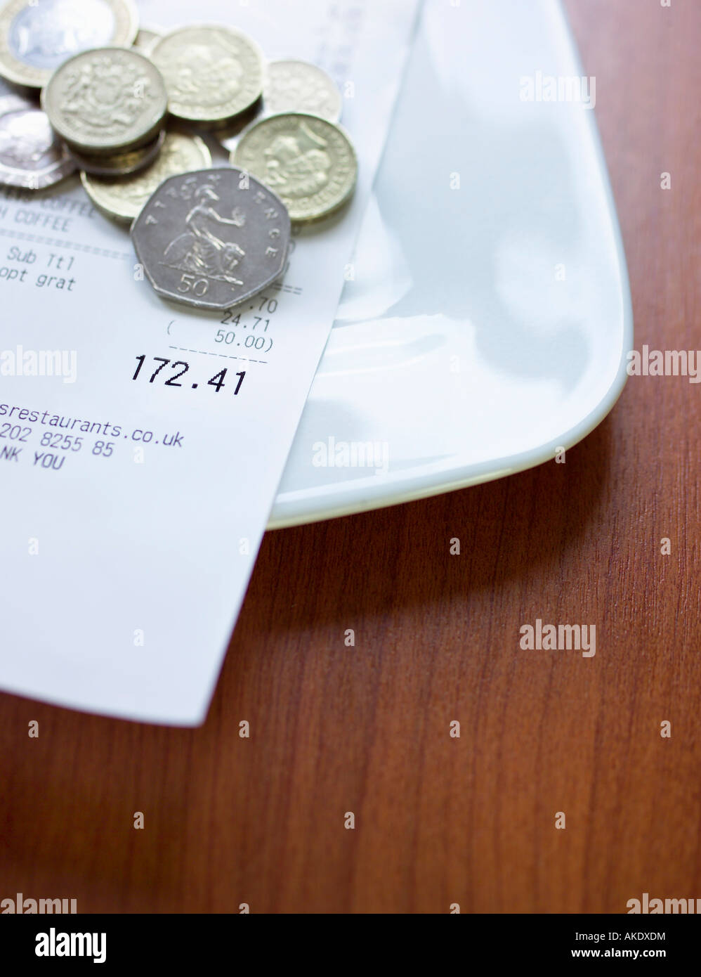 Pound monete e bill sulla piastra, close-up Foto Stock