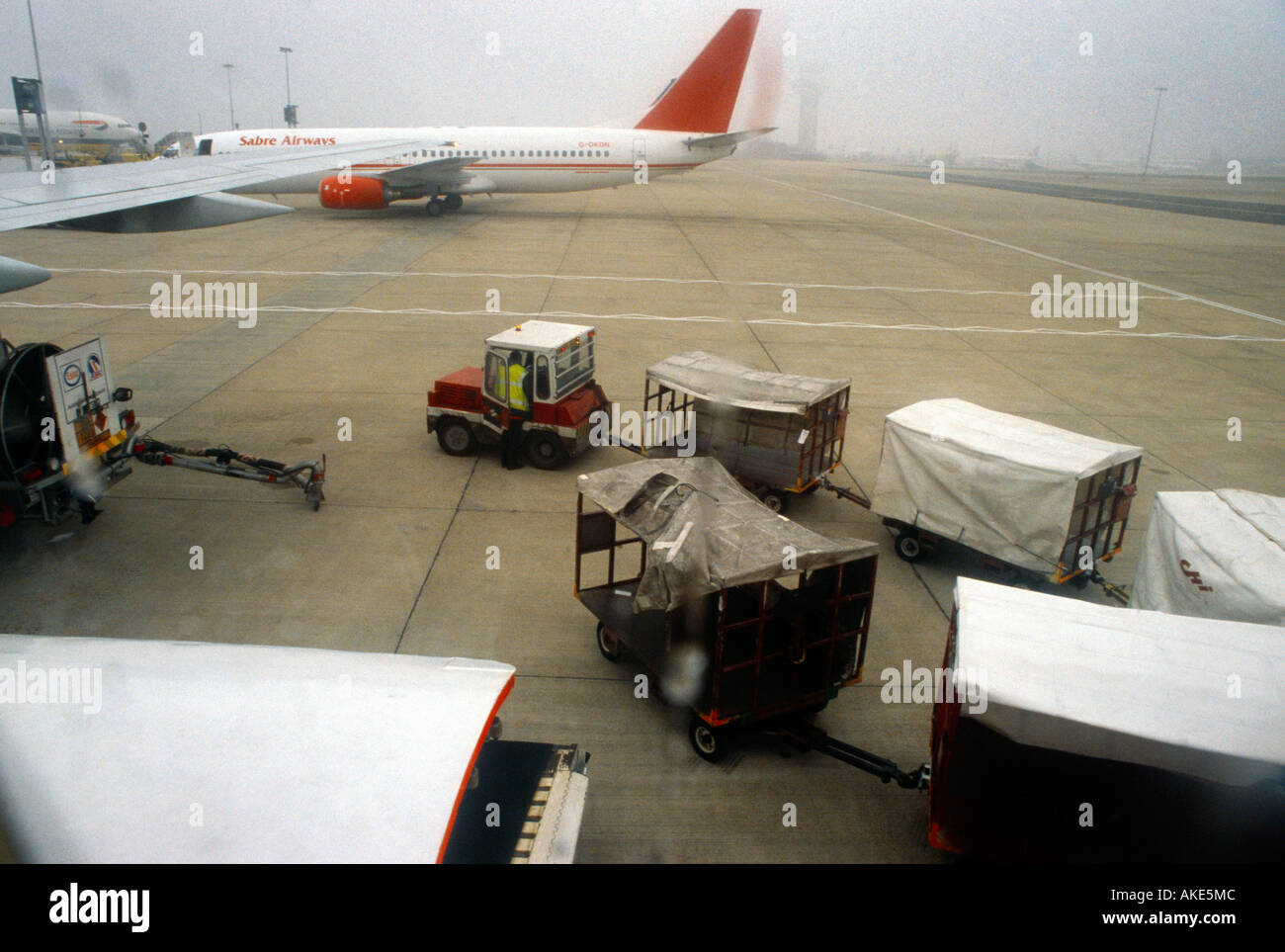 L' Aeroporto di Gatwick bagagli rimorchi su strada asfaltata andando al piano Foto Stock