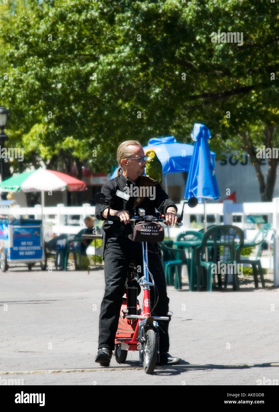 Un uomo in sella a uno scooter con un pappagallo colorato appollaiato sulle spalle alle Cascate del Niagara, New York, USA. Foto Stock