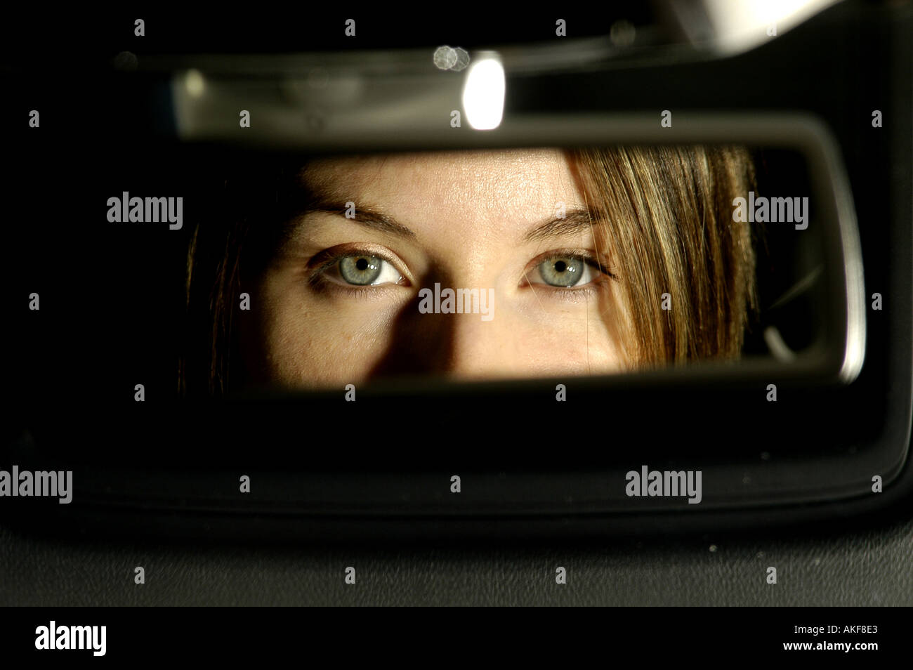 Prety giovani occhi di donna in VW 2004 mk 5 golf specchio retrovisore Foto Stock