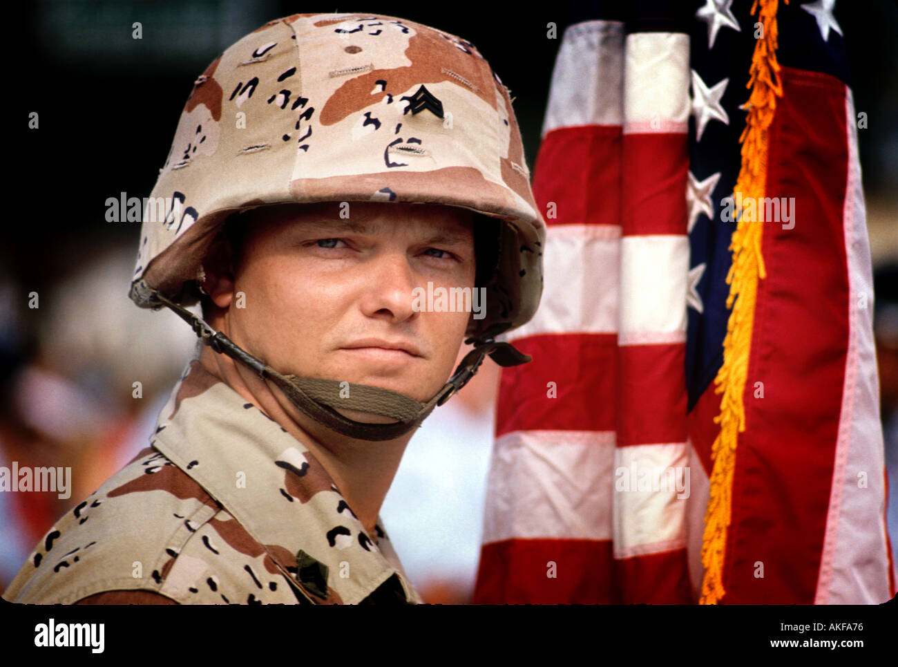 Giovane padre caucasico e volontario soldato con casco e bandiera americana Luglio 4th Parade dopo aver servito in Iraq Foto Stock