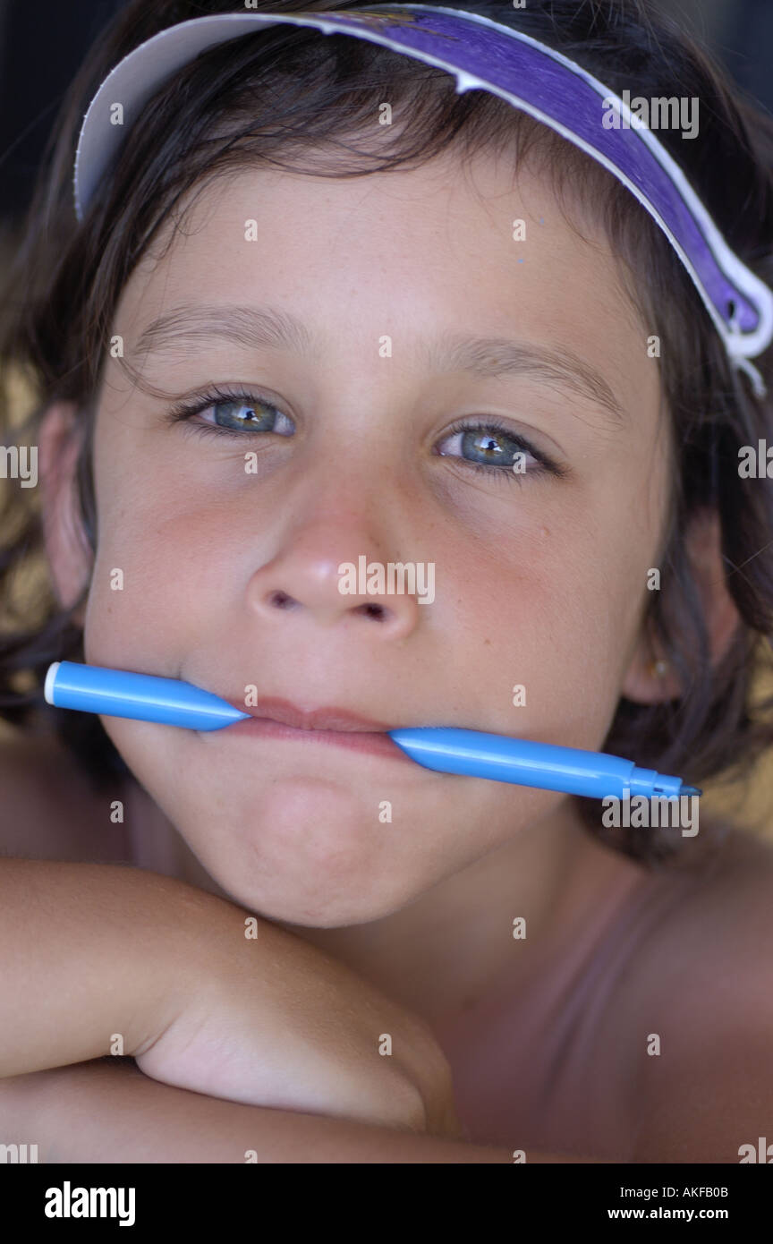 Bambina con la penna in bocca Foto stock - Alamy
