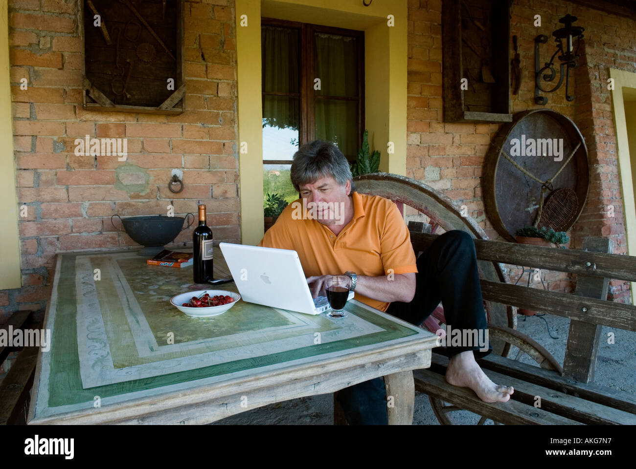 Uomo al lavoro con computer lap top presso un cantiere di vite e agriturismo in Toscana. Modello rilasciato self portrait. Foto Stock