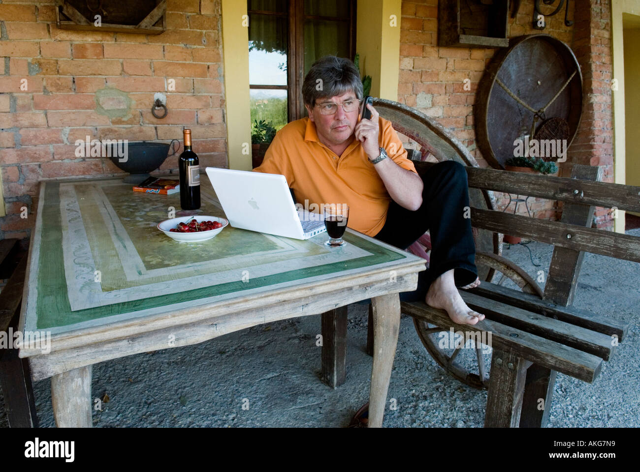 Uomo al lavoro con computer lap top presso un cantiere di vite e AGRITURISMO IN TOSCANA ITALIA Foto Stock