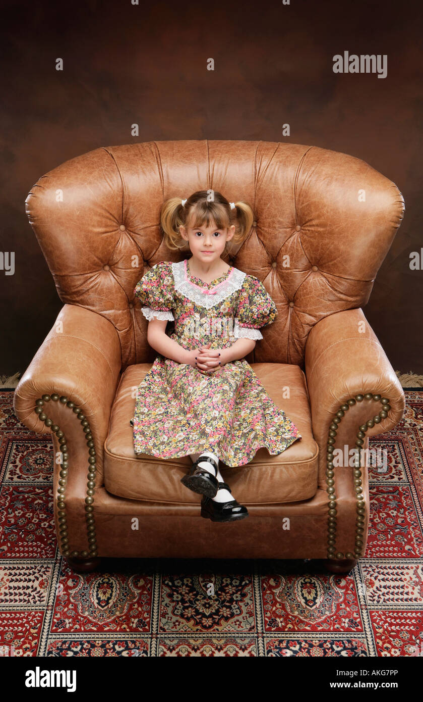 Ragazza seduta in poltrona di grandi dimensioni Foto Stock