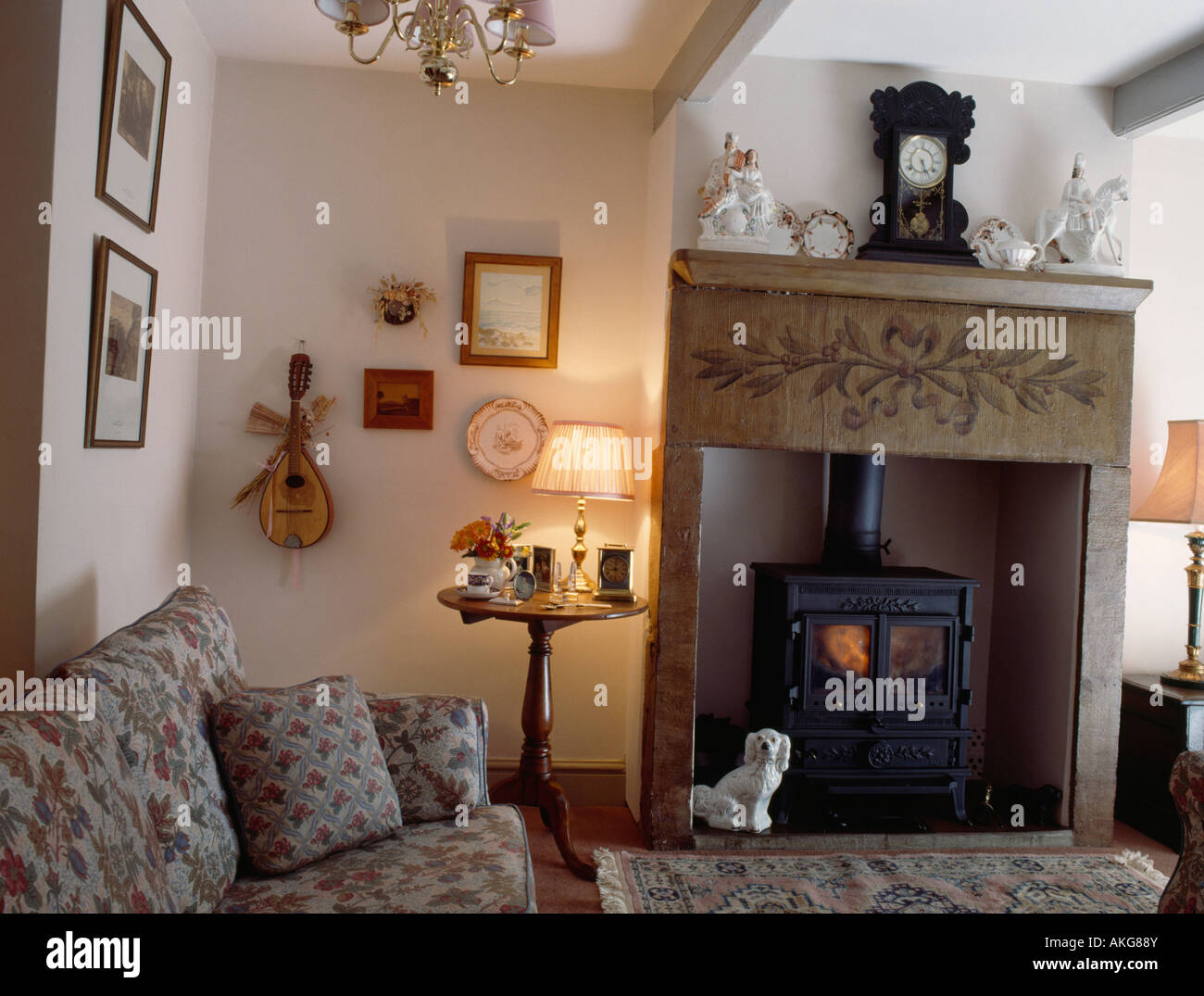 La Lampada sul tavolino accanto al caminetto verniciato nero con stufa e  orologio sul mantelpiece Foto stock - Alamy