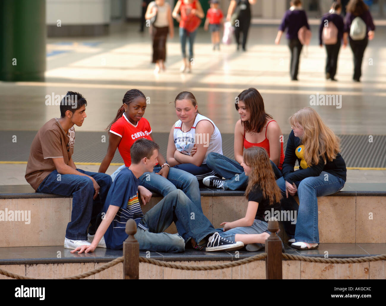 Un gruppo di ragazzi adolescenti e ragazze seduto a shopping arcade REGNO UNITO Foto Stock