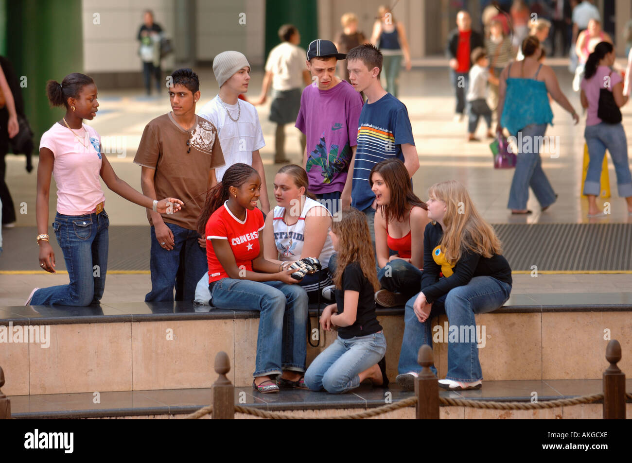 Un gruppo di ragazzi adolescenti e ragazze seduta in una galleria di negozi REGNO UNITO Foto Stock