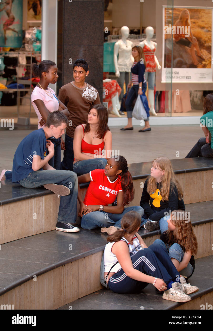 Un gruppo di ragazzi adolescenti e ragazze seduto a shopping arcade REGNO UNITO Foto Stock