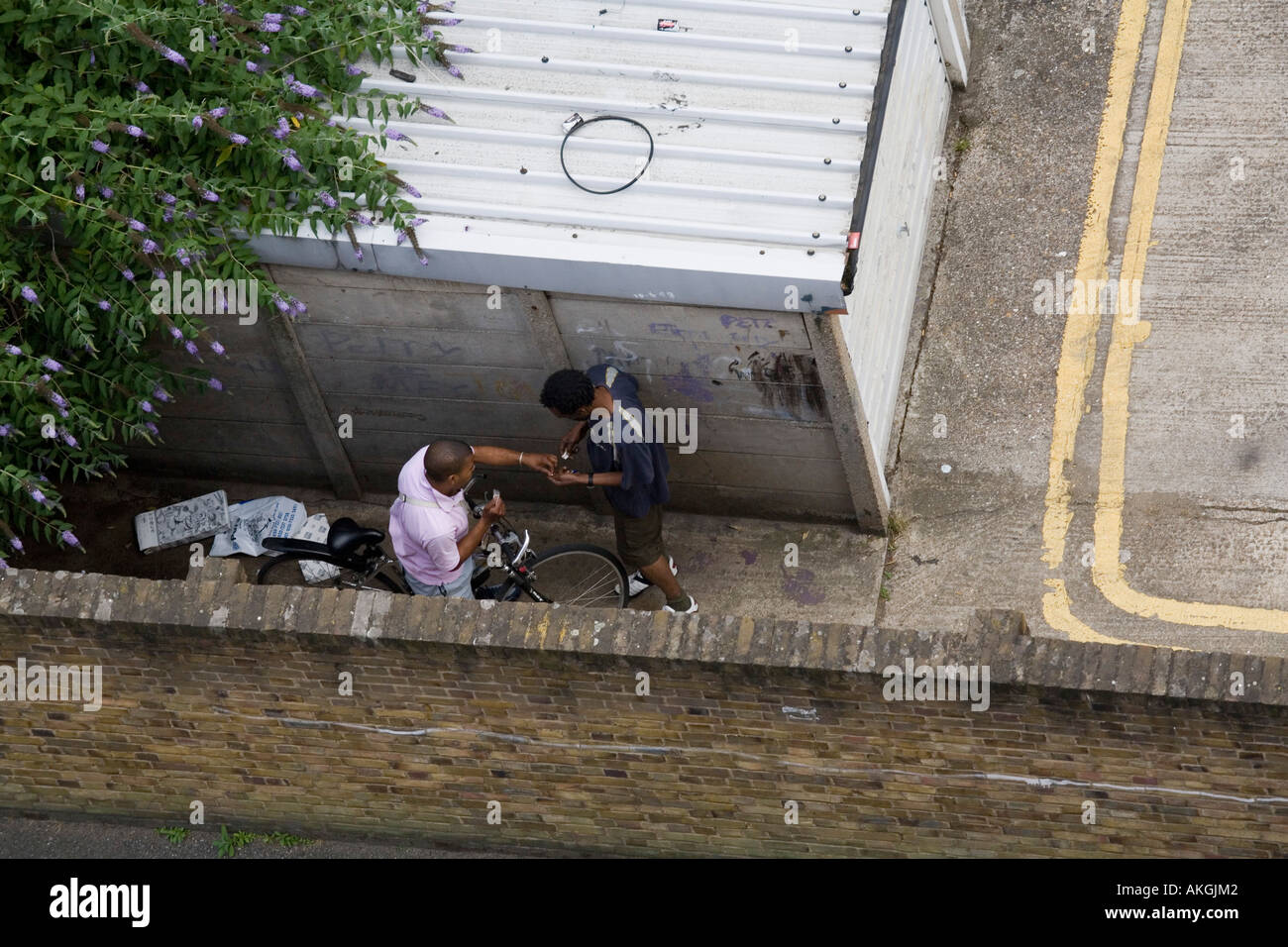 Il trafficante di droga nell'atto del passaggio di farmaci a un cliente in South London street Foto Stock
