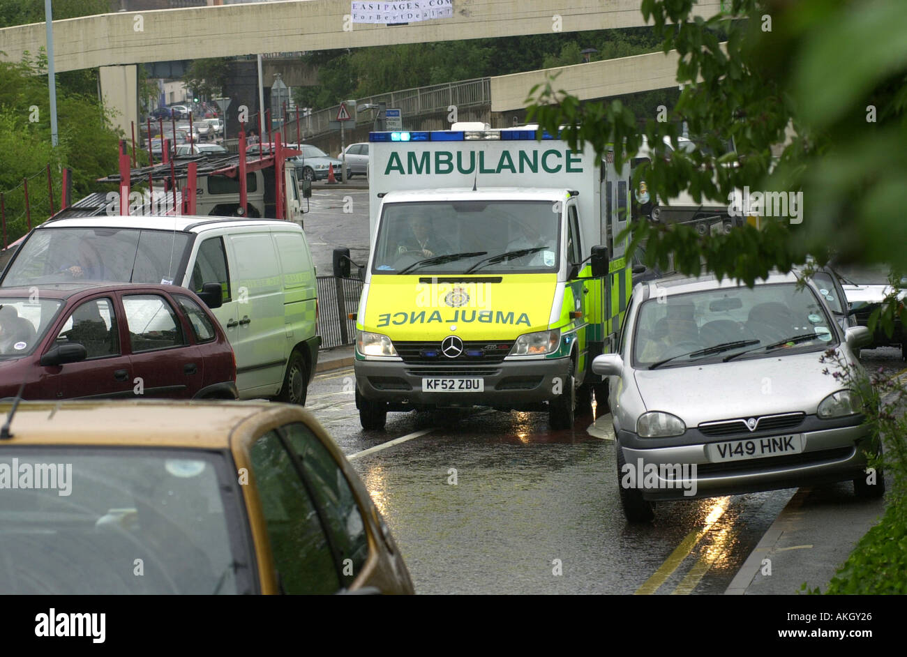 Un ambulanza si muove attraverso una strada trafficata sulla via di un'emergenza REGNO UNITO Foto Stock