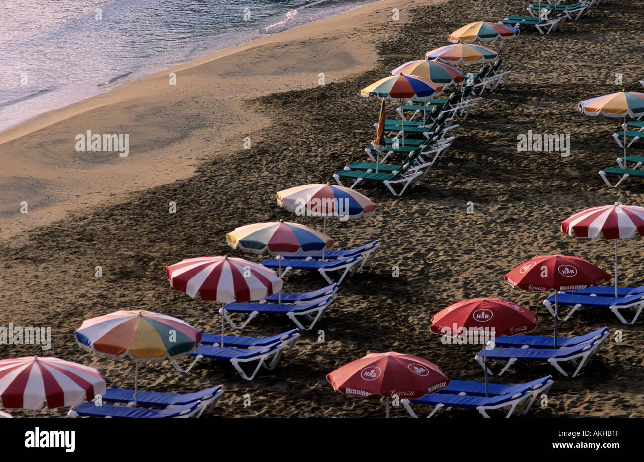 Spiaggia Spiaggia sundy tramonto Figueral bay, pieno con ombrelloni, Ibiza Isole Baleari Spagna Foto Stock