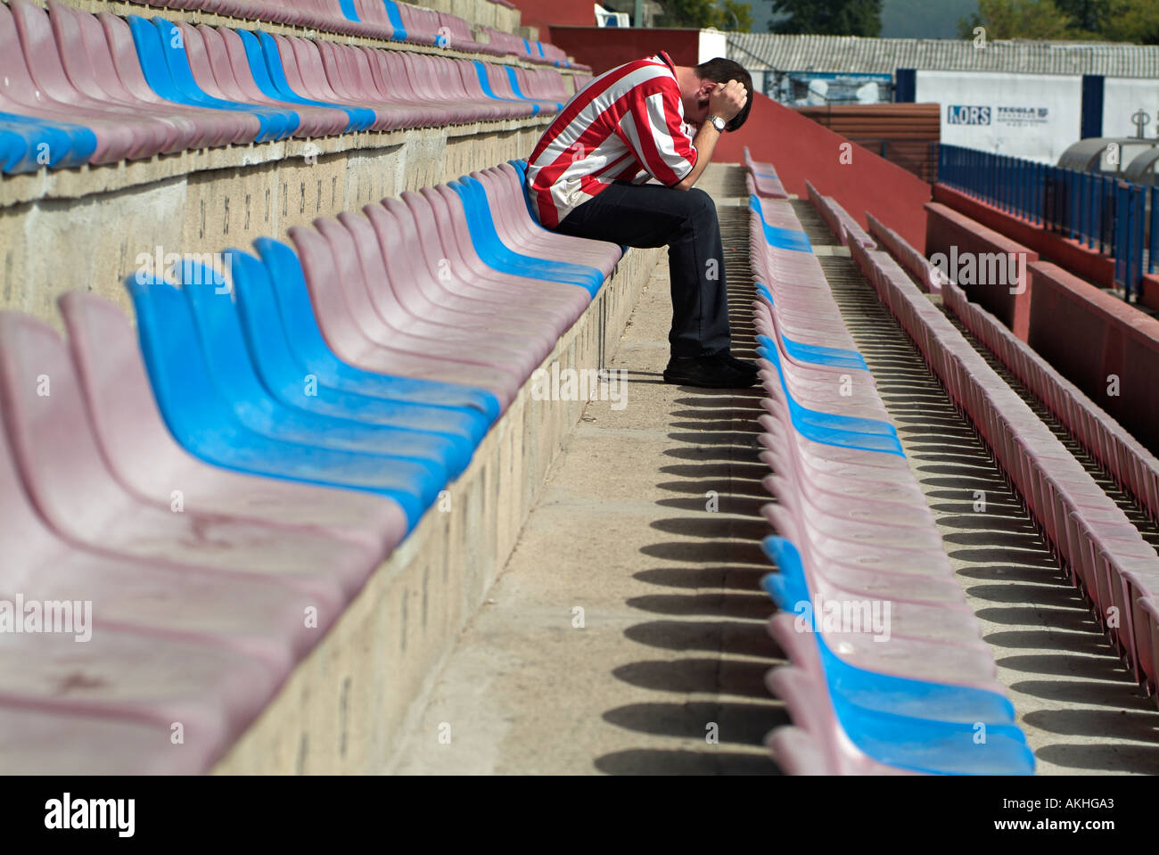 Premuto Football Soccer sostenitore seduto da solo in uno stadio vuoto dopo aver visto il suo team allentato. Foto Stock