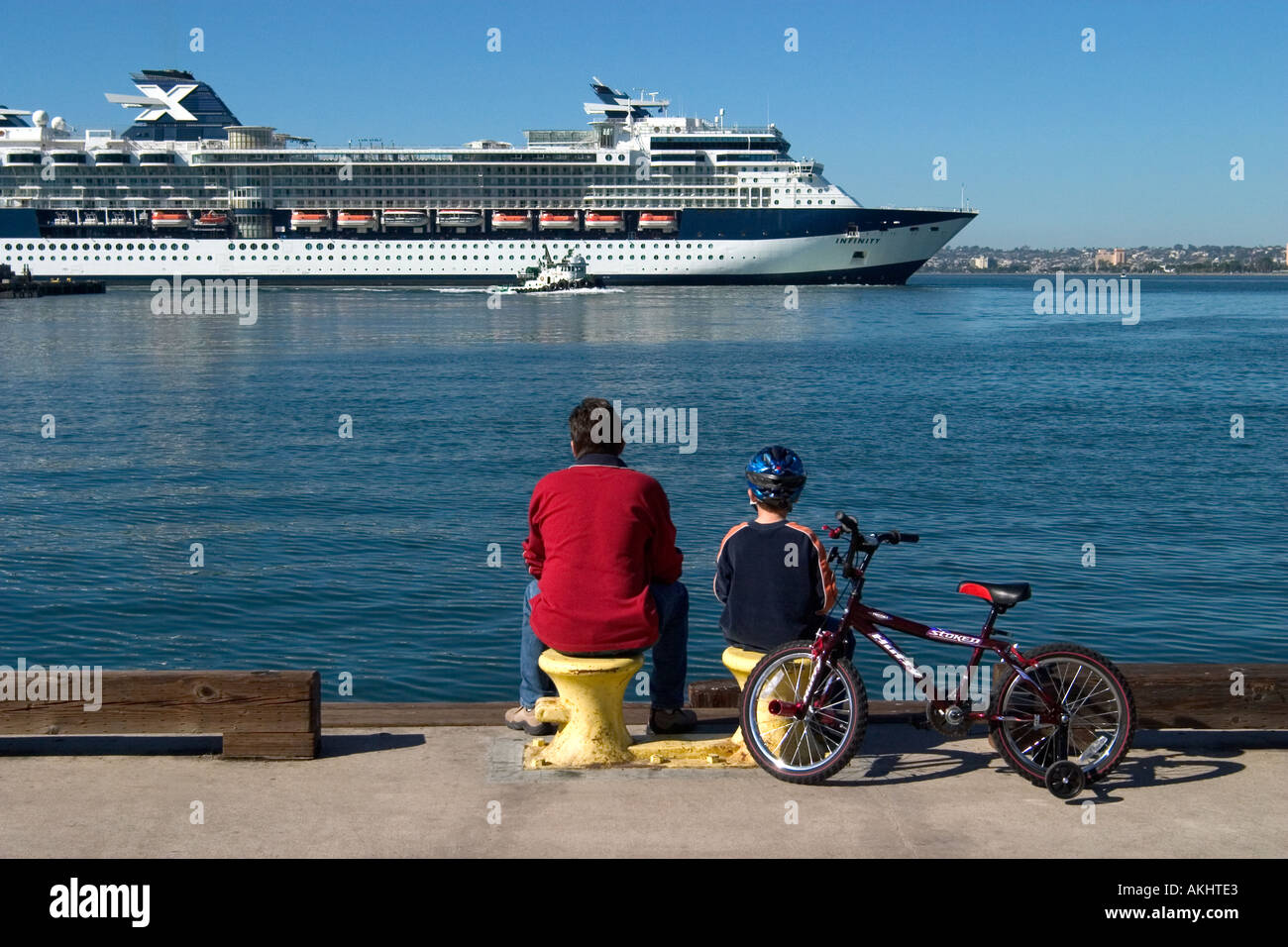 Un uomo e suo figlio guardando un ocean liner come esso si discosta in crociera Foto Stock