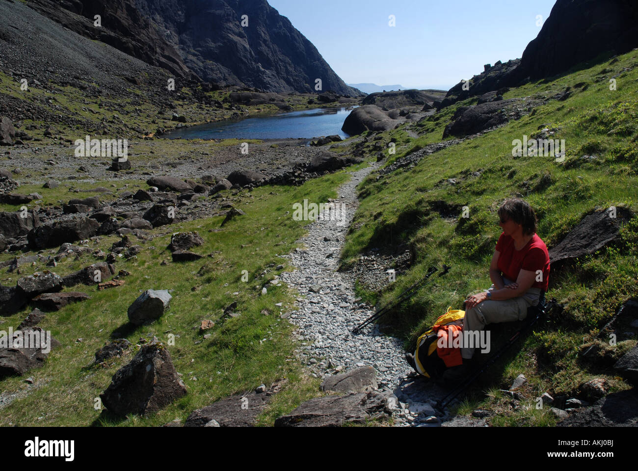 Escursionista in appoggio Coire Lagan Valley, Loch un Fhir Bhallaich, Cuillin Hills, isola di Skye, Ebridi Interne, Scozia Foto Stock