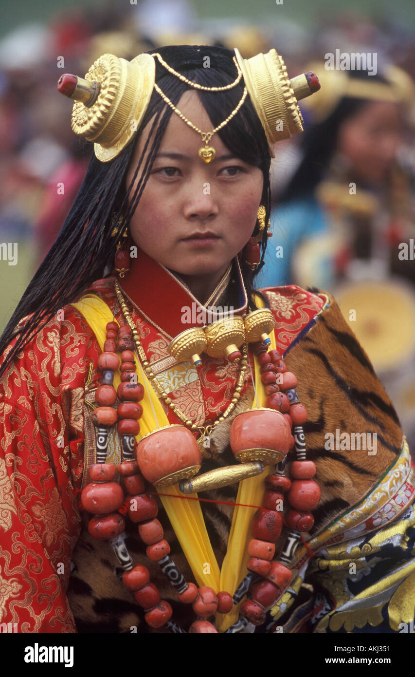 Khampa femmina indossa oro pezzi capelli scatole gau zee pietre corallo a Litang Horse Festival nella provincia del Sichuan in Cina Foto Stock