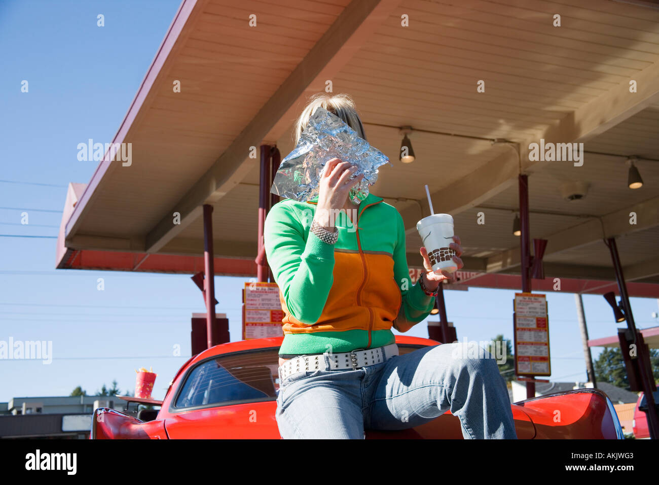 Donna di mangiare al drive in ristorante Foto Stock