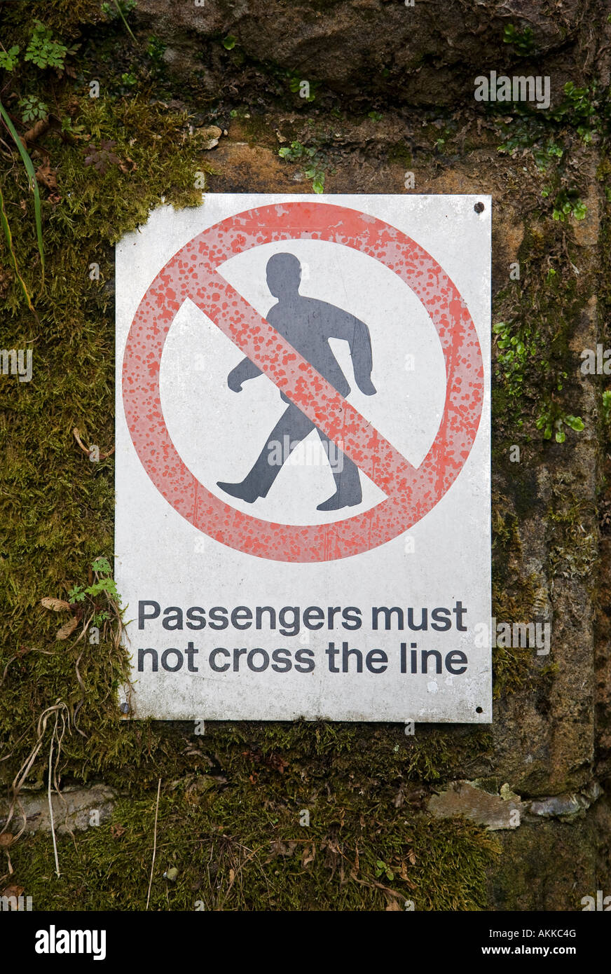 Segnale di sicurezza sulla piattaforma ferroviaria "passeggeri non devono attraversare la linea' Foto Stock