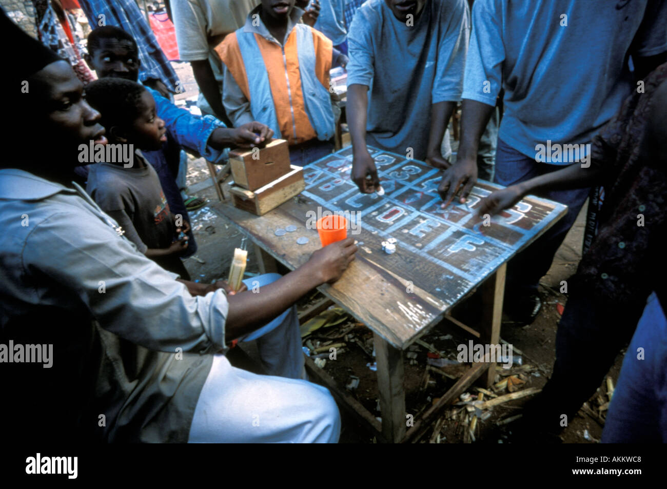 Gli uomini e i ragazzi giocando a un gioco d'azzardo in un mercato a Nampula Mozambico Foto Stock