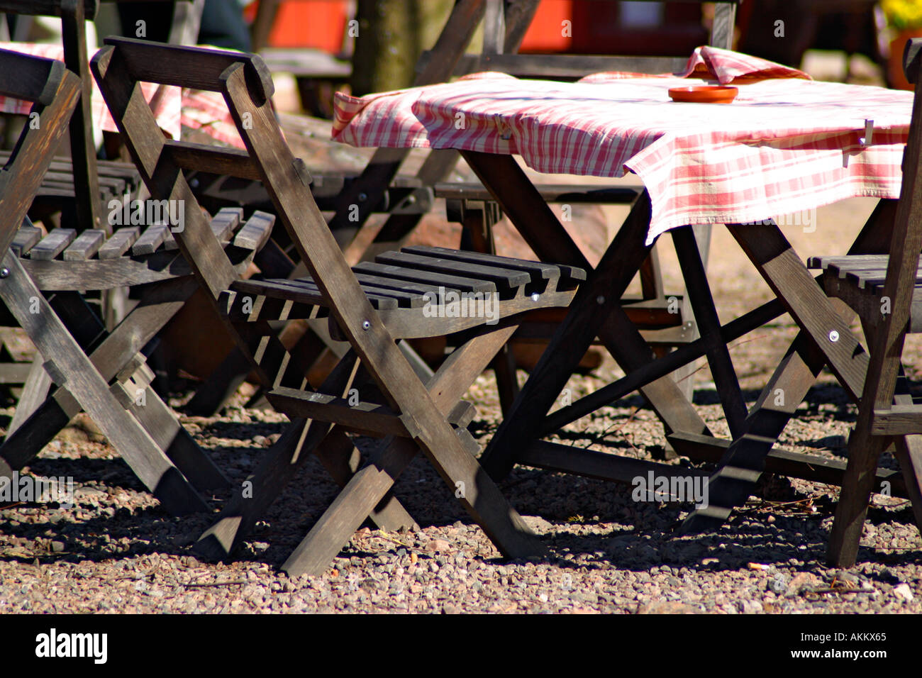 Outdoor cafe in primavera con mobili in legno e controllato le tovaglie in bianco e rosso Foto Stock