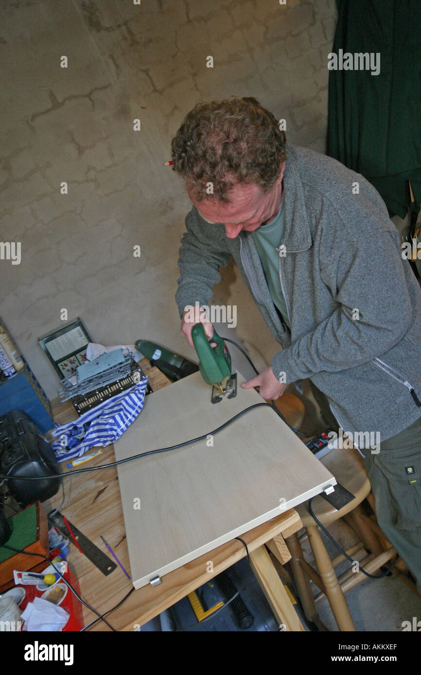 Uomo taglio del legno con il puzzle Foto Stock