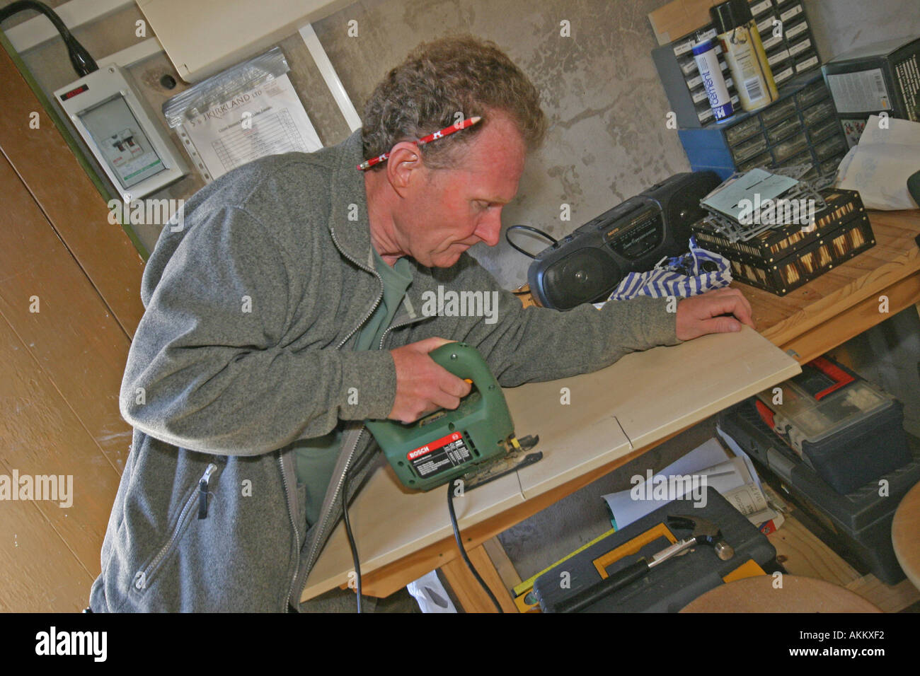 Uomo taglio del legno con il puzzle Foto Stock