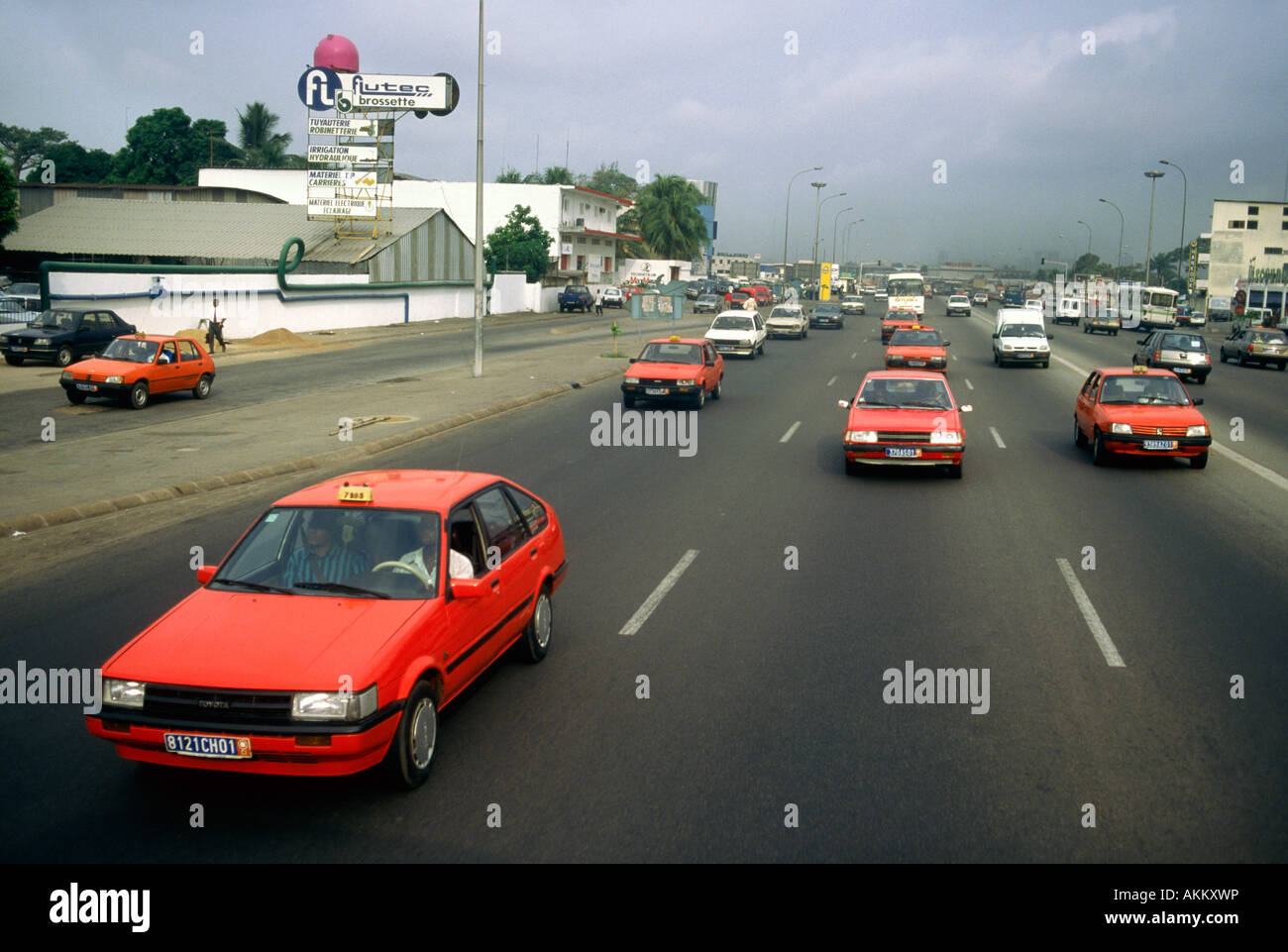 I taxi di colore arancione sulla trasmissione a sei corsie di Abidjan in Costa d Avorio Foto Stock