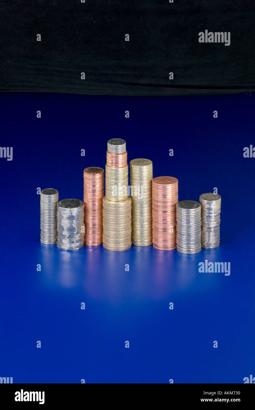 Pile di monete Britanniche sfondo blu Foto Stock