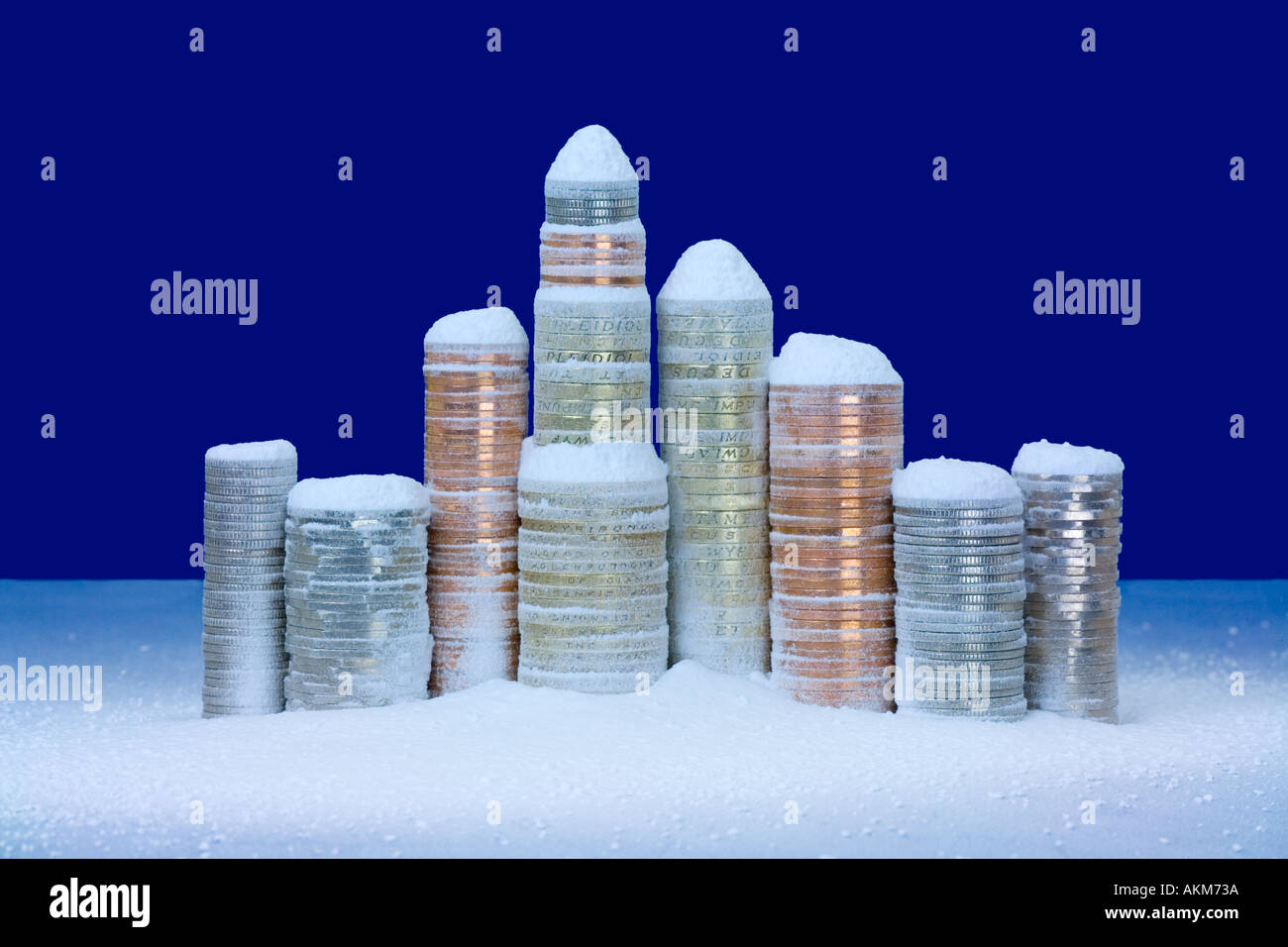 Pile di monete Britanniche nella neve Foto Stock