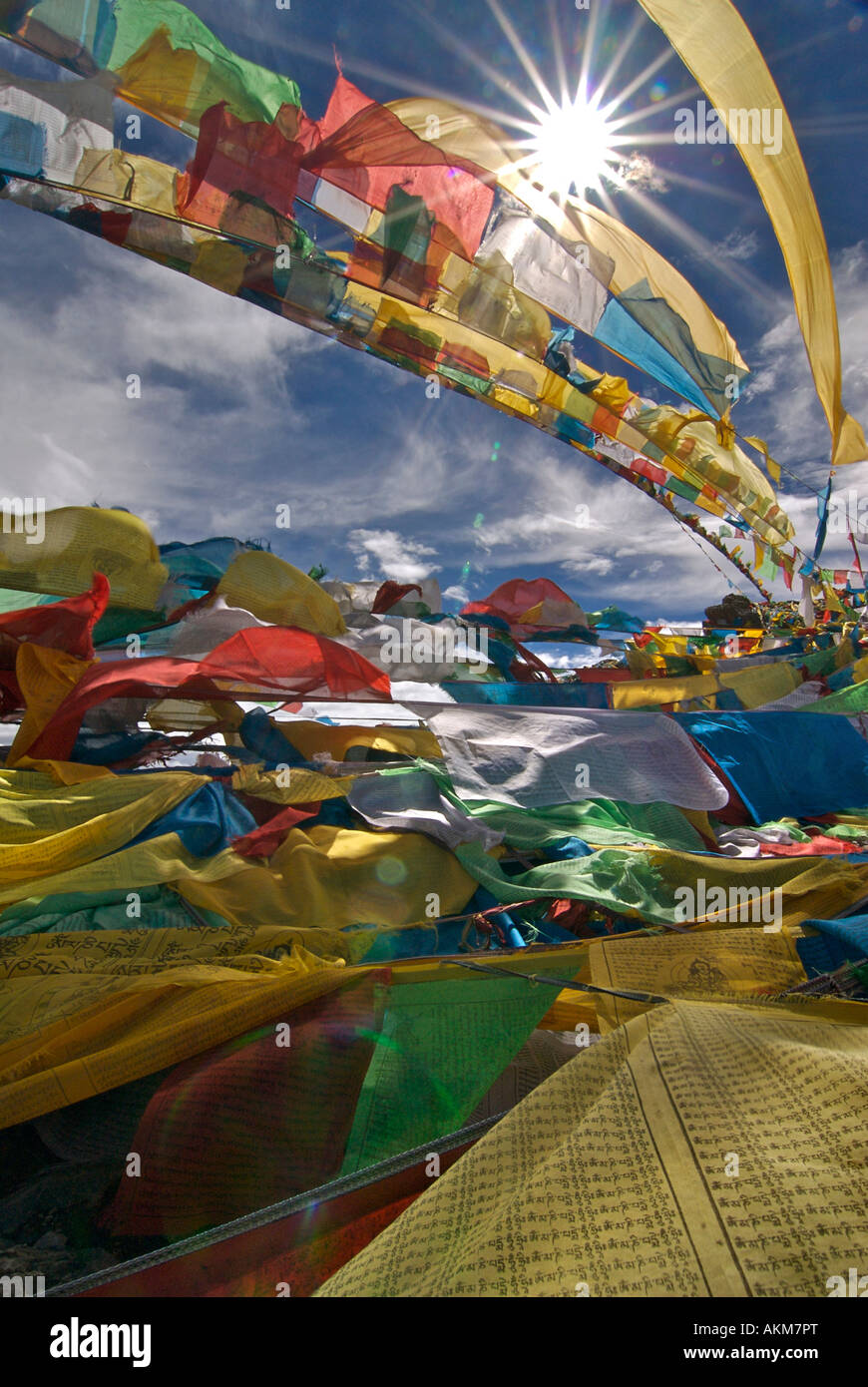 Bandiere di preghiera sbattimenti nel sole di mezzogiorno sulla cima di un affioramento al lago Namtso Tibet Foto Stock