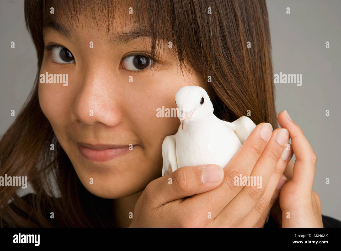 Una donna che mantiene una colomba Foto Stock