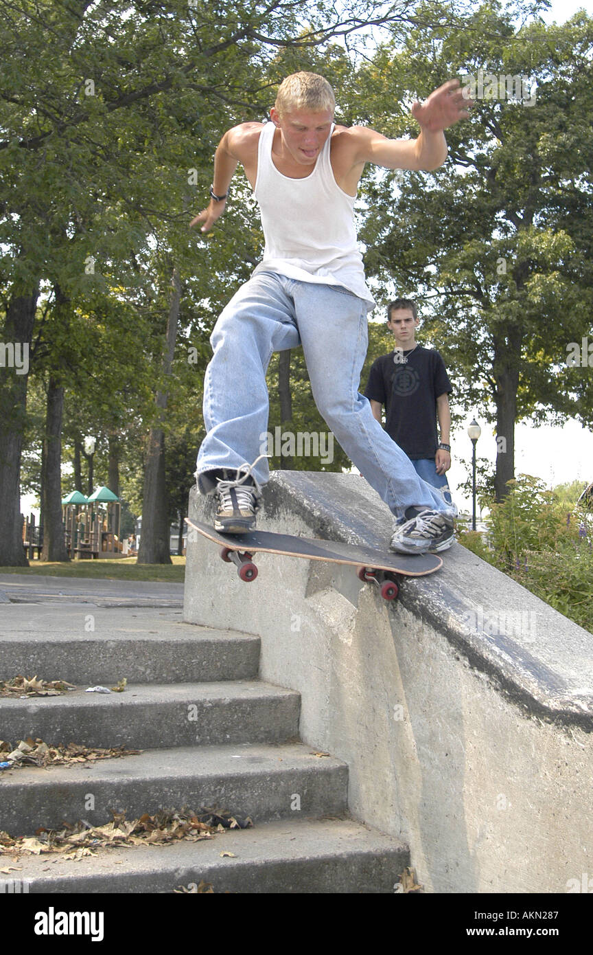 Teens pratica skate manovre di bordo in un parco pubblico Foto Stock