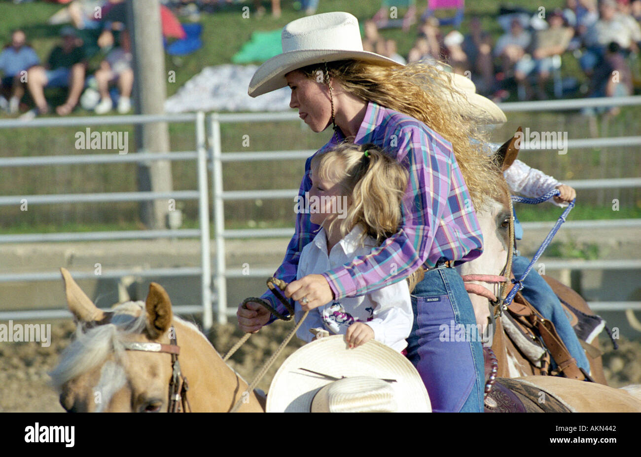 La madre e il bambino ride l'anello di centro durante il rodeo a metà tempo Foto Stock