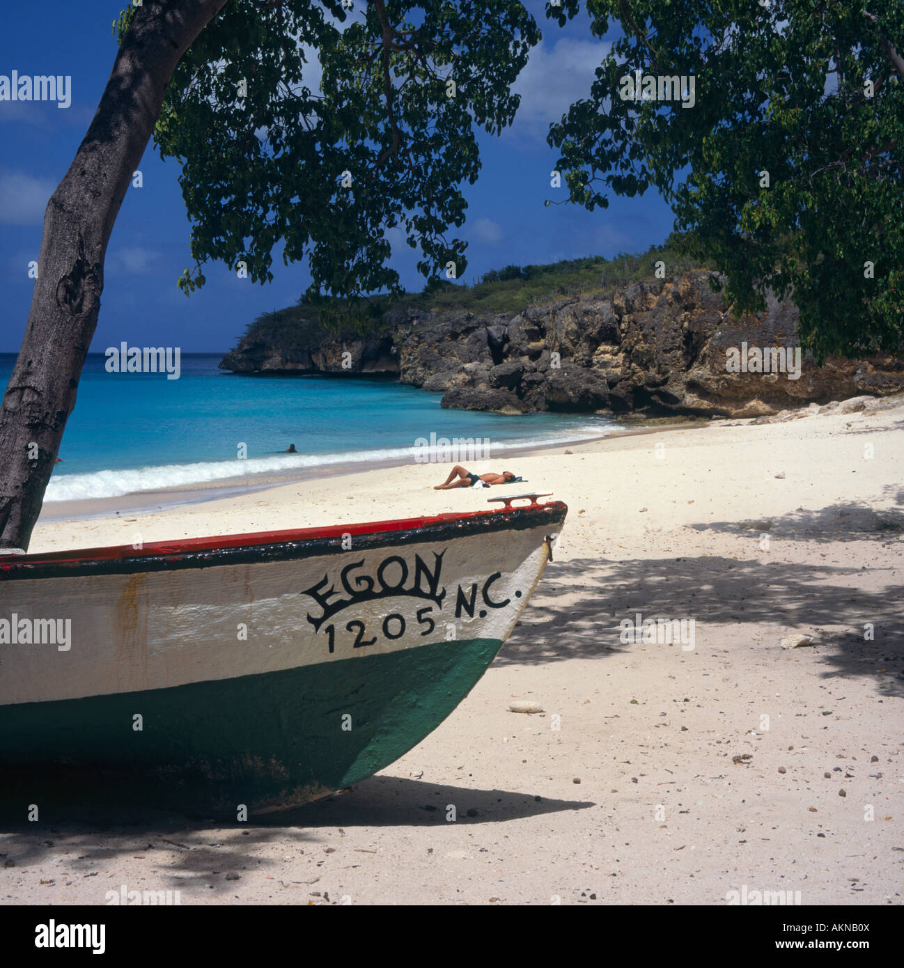 La parte anteriore della piccola imbarcazione locali elaborati sulle sabbie di Playa Jeremi Beach con la persona a prendere il sole al di là su Curacao Caraibi Foto Stock