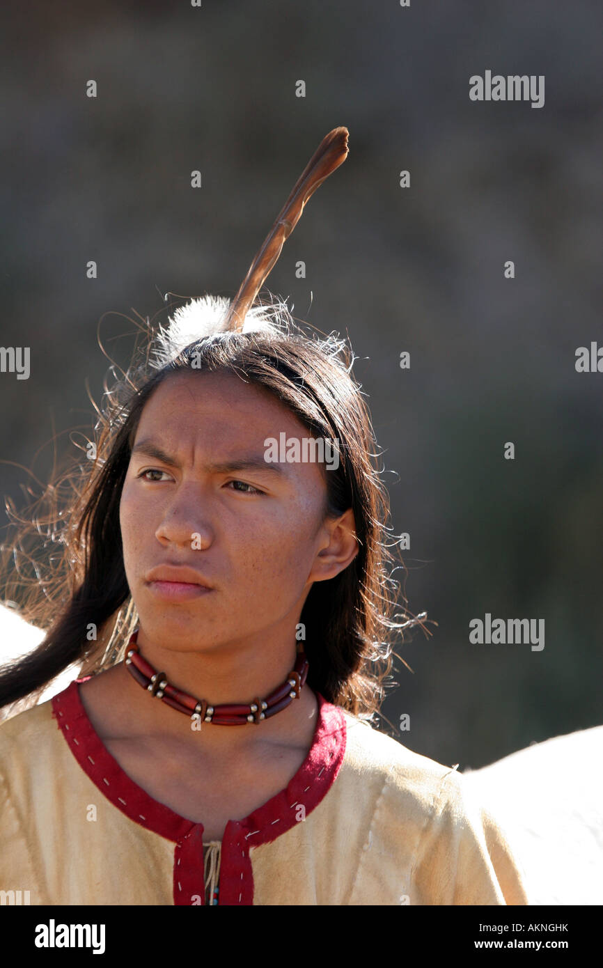 Un Native American Indian boy indossando una piuma in piedi accanto a quella di un cavallo Foto Stock