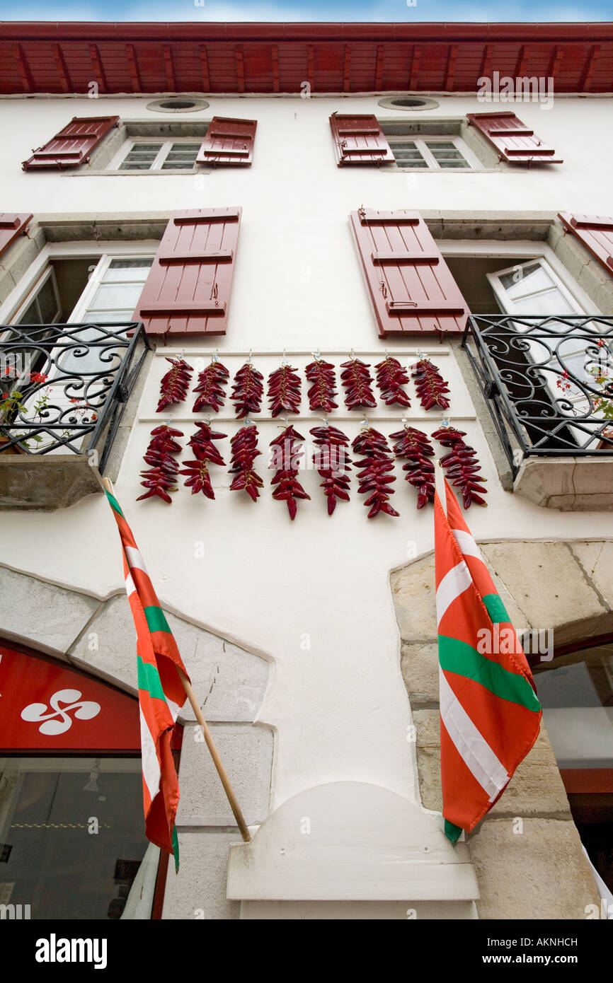 In Espelette peperoni, appendere fuori su una tipica casa basco anteriore (Francia). Facciata de maison et piments suspendus (Francia). Foto Stock