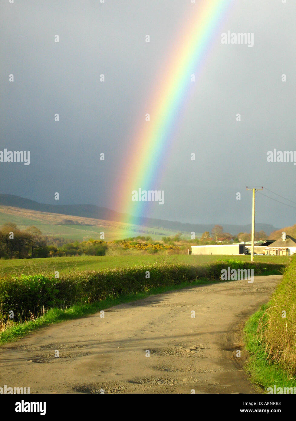 Rainbow in scena rurale contro il cielo scuro Foto Stock